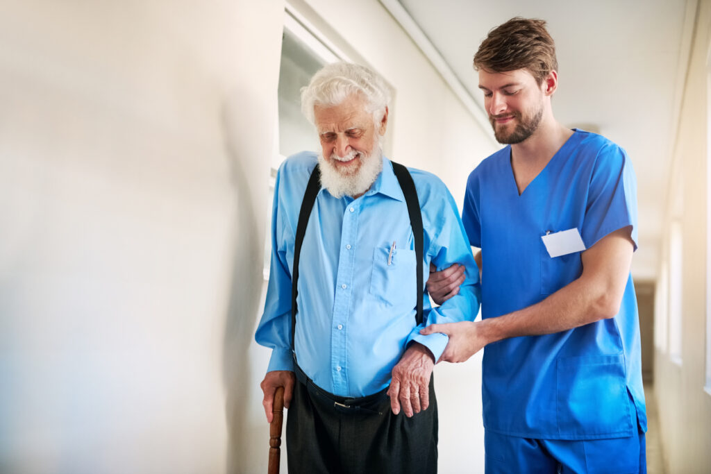 personne âgée en perte d'autonomie aidée par un personnel soignant pour sa rééducation à la marche dans une maison de retraite ou un hôpital